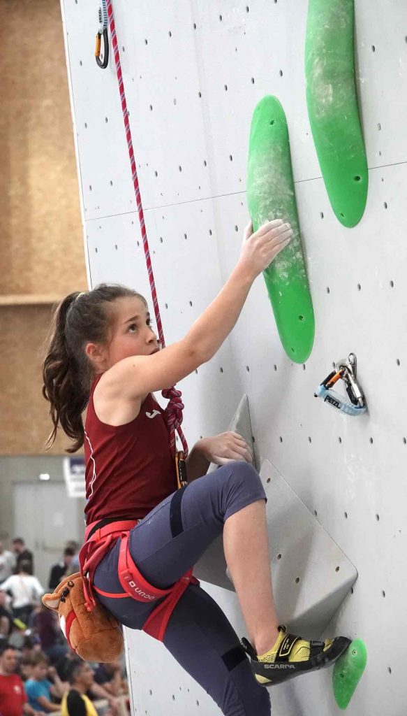grimpeuse enfant sur un mur d'escalade