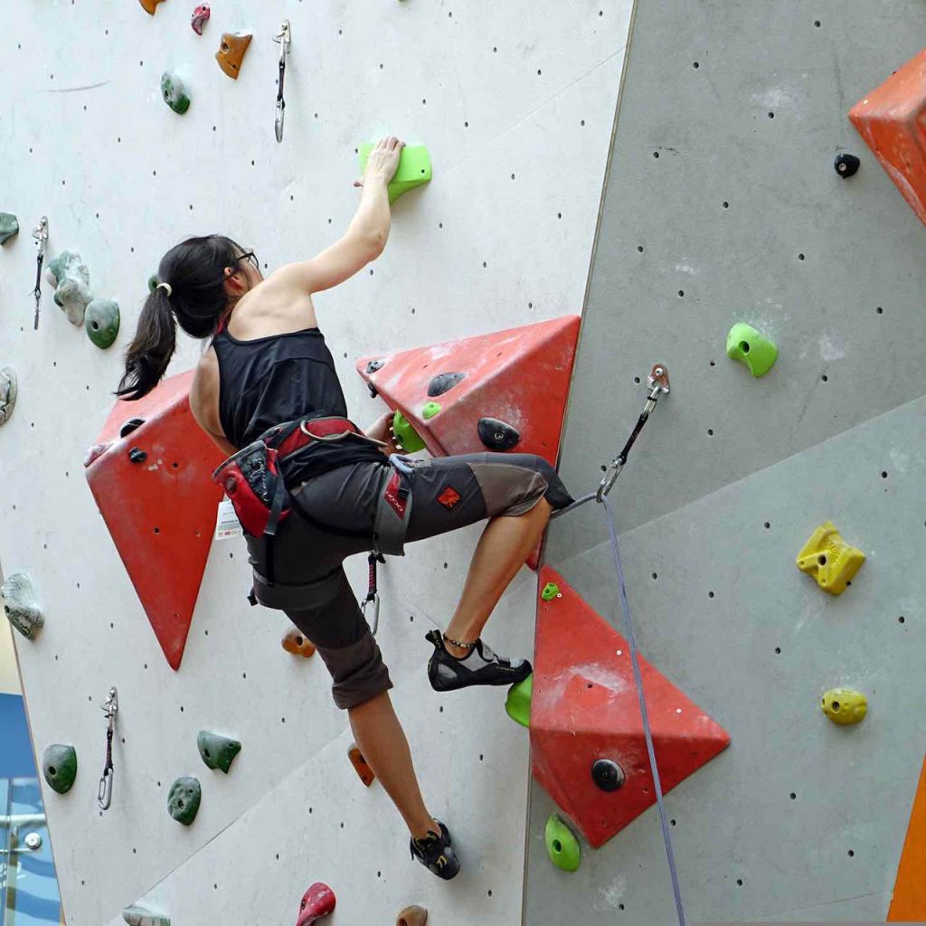 une grimpeuse sur un mur d'escalade